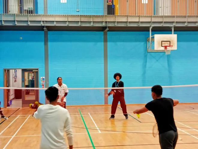 A group of Young People playing Badminton with one of our Youth Workers
