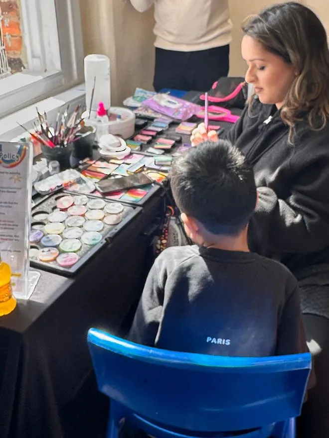 Youth worker doing face painting for a young person