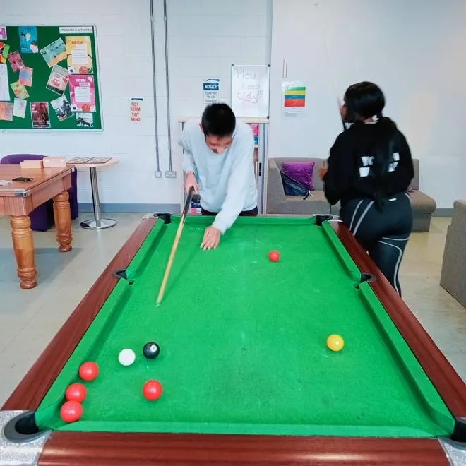 A Young Person playing snooker/pool with one of our Youth Workers