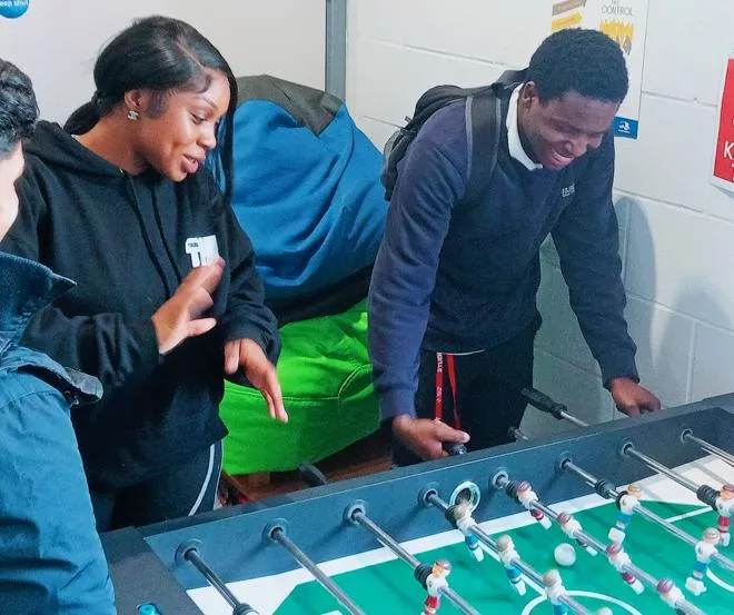 Youth Worker playing table football with Young People