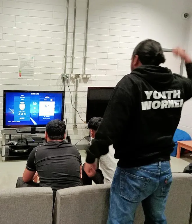 Youth Worker playing PS5 with a Young People